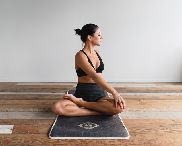 Woman practising yoga on mat