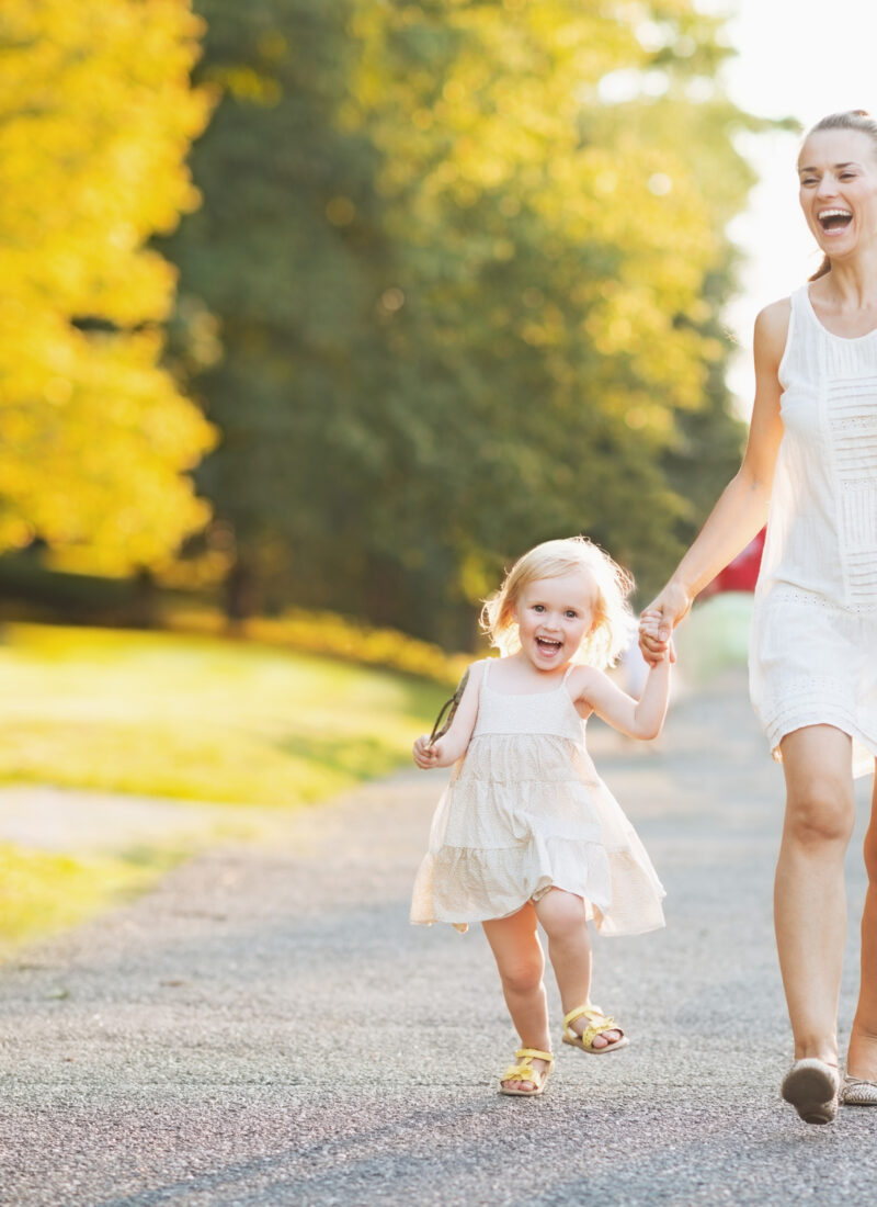 Happy mother and child walking hand-in-hand.